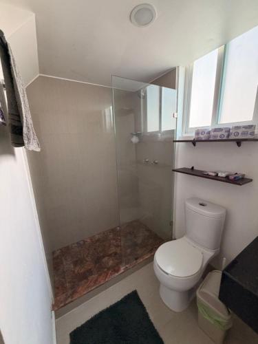 a bathroom with a toilet and a glass shower at Departamento Conjunto Mirador in Santa Cruz Huatulco