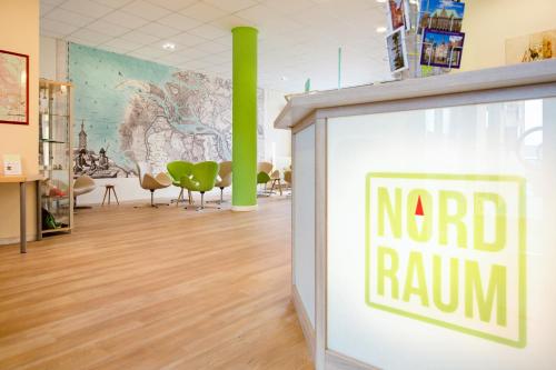 a sign that reads nordrum in a room with chairs at Hotel NordRaum in Bremen