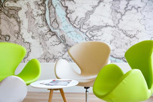 a room with green and white chairs and a map at Hotel NordRaum in Bremen