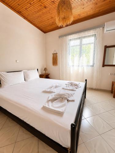 a bedroom with a large white bed with towels on it at Ambelos, Lesvos Beach House in Koustáros
