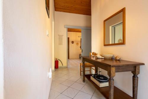 a dining room with a table and a mirror at Ambelos, Lesvos Beach House in Koustáros