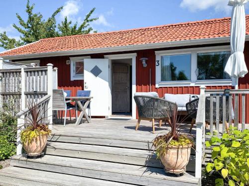 a red house with a deck with a table and chairs at 4 star holiday home in onsala in Onsala