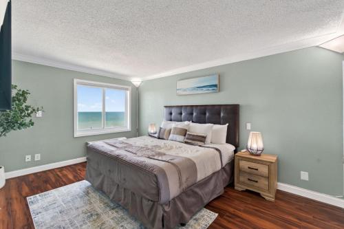 a bedroom with a large bed and a window at Oceanfront Beach Condo, Pool, Gym, Fishing Surfing in Virginia Beach