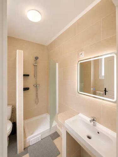 a bathroom with a sink and a toilet and a mirror at Hotel de la gare in Pantin