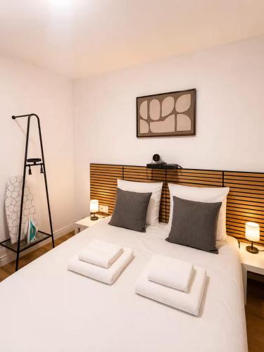 a bedroom with a large white bed with two pillows at Hotel de la gare in Pantin