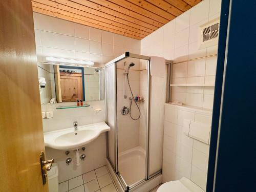 a bathroom with a shower and a sink and a toilet at Residenz am Park in Sankt Johann in Tirol