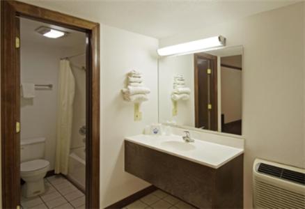 a bathroom with a sink and a toilet and a mirror at Executive Inn Muldrow in Muldrow