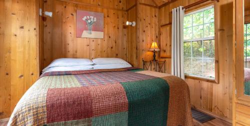 a bedroom with a bed in a wooden cabin at Engadine Inn and Cabins in Candler