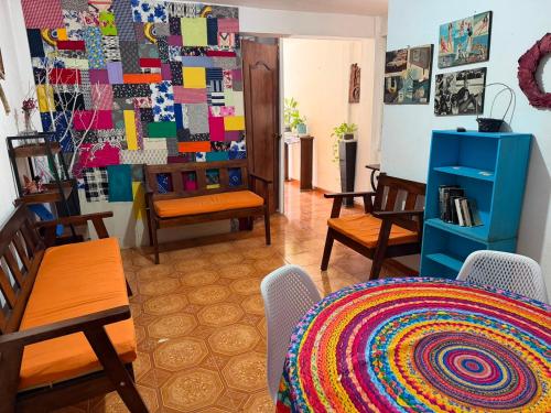 a living room with a table and chairs and a wall of art at Las Huellas del Caminante in Catemaco
