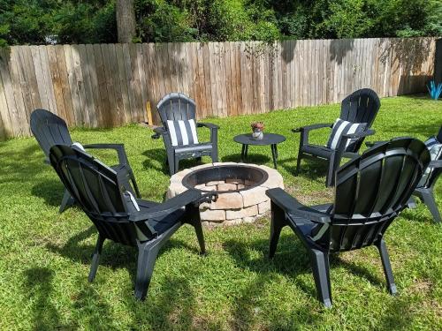 a group of chairs and a fire pit in a yard at The Lemon Zest Cottage Paws Welcome in Pensacola