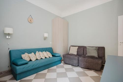 a living room with a blue couch and a chair at Cavour 96 Apartment in Florence