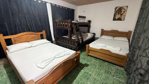 a bedroom with two beds and a crib at Hotel Casa Molina in Coveñitas