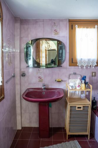 a bathroom with a red sink and a mirror at Pietra Mare Suites Villa in Palaión Eleftherochórion