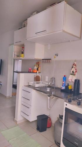 a kitchen with white cabinets and a sink at Casa Aconchegante S8km do parque do peão in Barretos