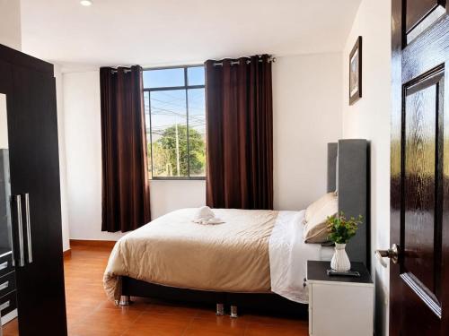 a bedroom with a bed and a large window at Villa Garden in Ica