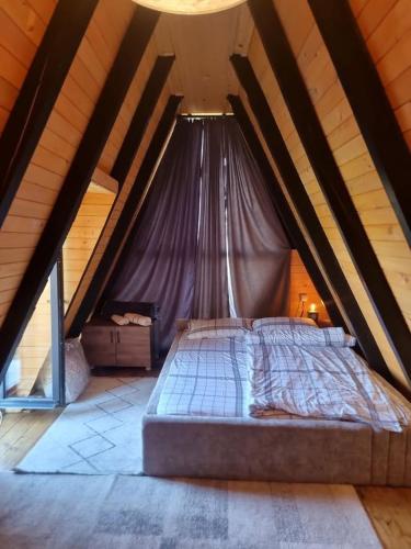 a bed in a attic with a roof at Villa Leos in Ferizaj