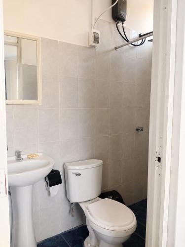 a bathroom with a toilet and a sink at Villa Garden in Ica