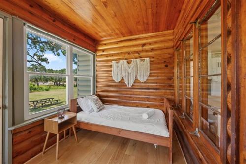 a bedroom with a bed in a log cabin at Cedar Nest - Lakefront Cabin Retreat in Madill