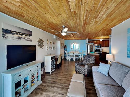 a living room with a couch and a flat screen tv at My Happy Place in Mustang Beach