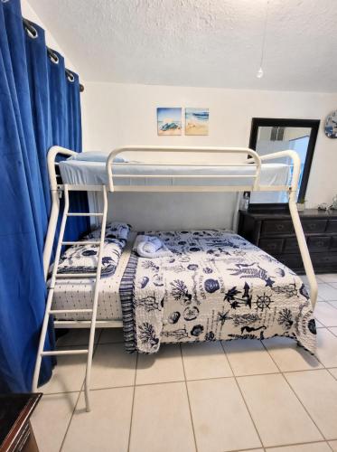 a bunk bed in a room with blue curtains at Coco Sol 2 by MyMiamiStay in Miami