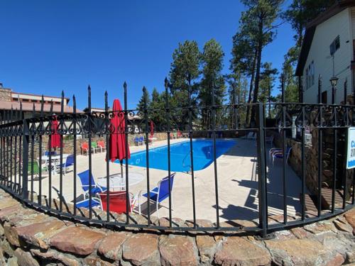a metal fence with chairs and a swimming pool at Hold Your Horses in Ruidoso