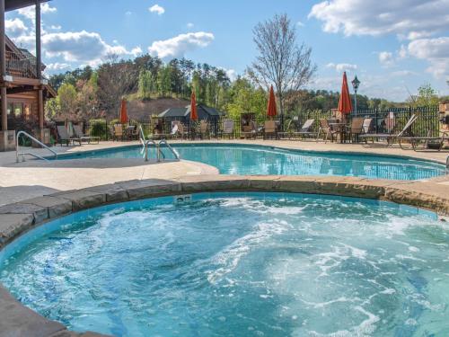 a pool at a resort with tables and chairs at Lazy Bears Den 2103 in Pigeon Forge