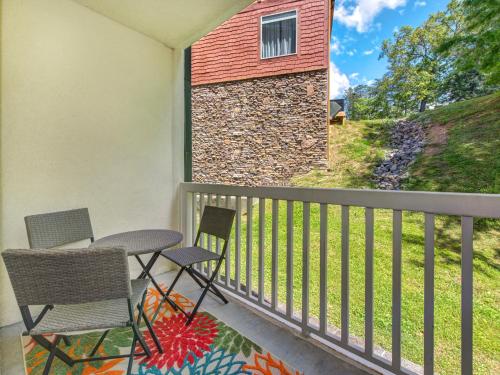 a balcony with two chairs and a stone wall at Lazy Bears Den 2103 in Pigeon Forge