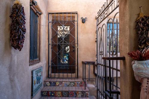 an entrance to a house with a gate and a door at Casita Mariposa in Santa Fe