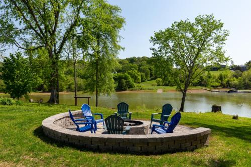 a group of chairs sitting around a circular fire pit by a lake at Sunrise Cove in Dandridge