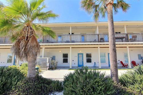 a house with palm trees in front of it at Surfin Seahorse in Port Aransas