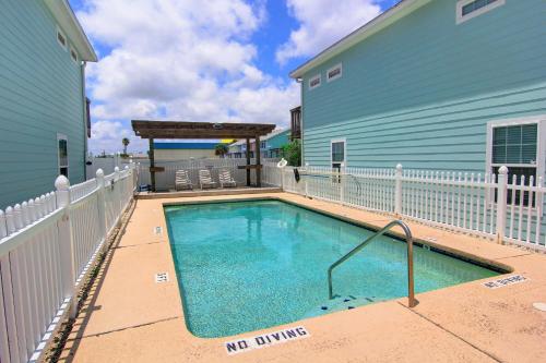 a swimming pool in front of a blue building at Surfin Seahorse in Port Aransas