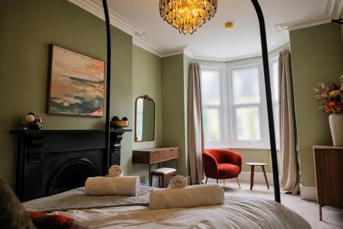 a bedroom with a bed and a mirror and a chair at Fox House Llandudno in Llandudno