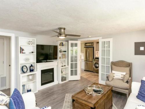 a living room with a couch and a tv at Cape Cod Cottage in Port Aransas
