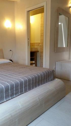 a bedroom with a bed and a mirror in it at La casa di Pier in Olbia