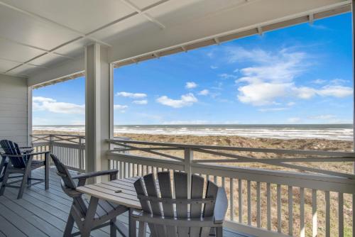 a porch with chairs and a table and a view of the beach at Itll Do in Padre Island