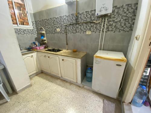 a small kitchen with a stove and a refrigerator at Raies in Akouda