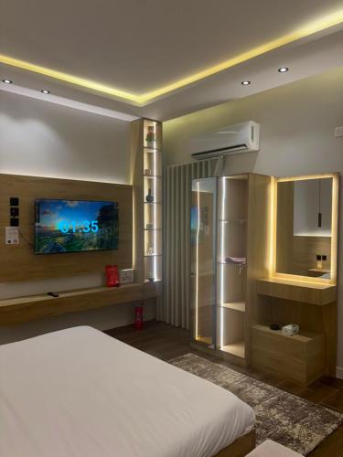 a bedroom with a white bed and a tv at لين سويت in Khamis Mushayt