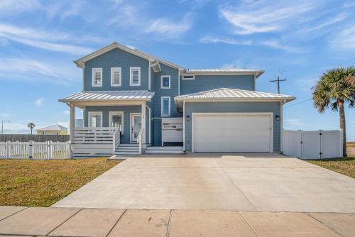 a blue house with a white fence and a driveway at Downtime in Padre Island