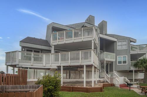 a large house with balconies and a yard at Pawsitively Paradise in Mustang Beach