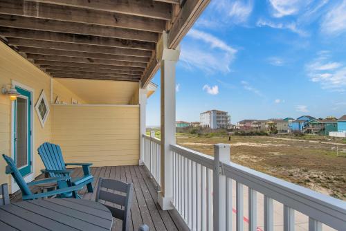 two chairs and a table on a porch with the beach at Sandbar in Port Aransas