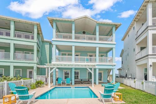 aominium building with a swimming pool and chairs at Beach-A-Holic in Padre Island