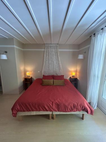 a bedroom with a large red bed with a ceiling at Auberge des Veillees in Blesle