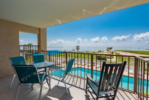 a balcony with a table and chairs and a view of the beach at Laguna Reef #208 - Sea Happiness in Rockport