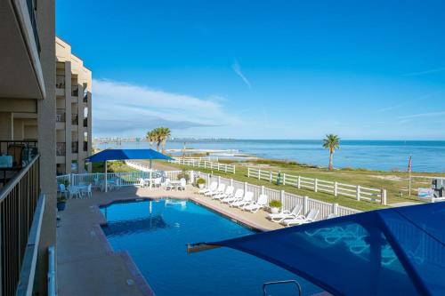 a view of a swimming pool with chairs and the ocean at Laguna Reef #212 - Shore 2 Please in Rockport
