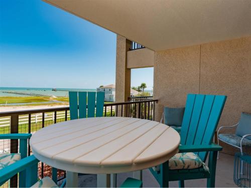 a table and chairs on a balcony with the beach at Laguna Reef #213 - Four Point Lighthouse in Rockport