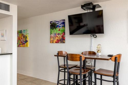 a dining room with a table with chairs and a flat screen tv at Laguna Reef #215 - Tequila Sunrise in Rockport