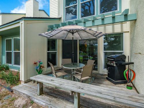 a picnic table with an umbrella and a grill on a deck at Beautiful Bay View Condo in Rockport