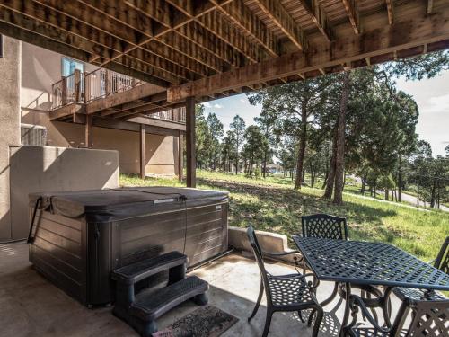 an outdoor patio with a grill and a table and chairs at Avalon in Ruidoso