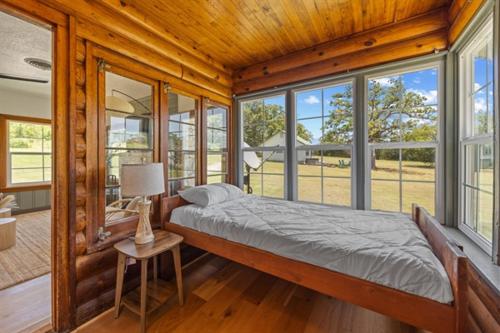 a bedroom with a bed in a room with windows at Willow Heaven - Lakefront Cabin Escape in Madill