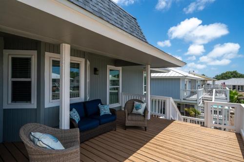 a porch with a blue couch and chairs on a house at Edgewater Escape in Rockport